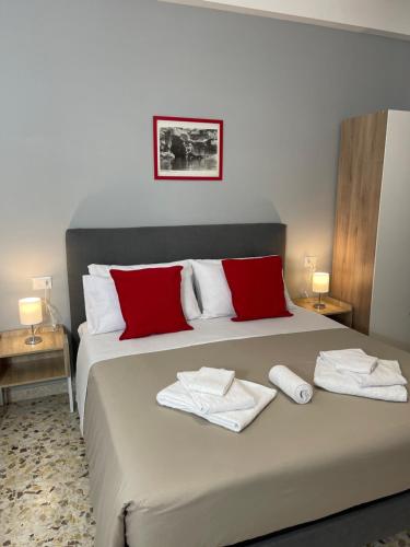 um quarto com uma cama com toalhas vermelhas e brancas em Trastevere Station Sweet Rest em Roma