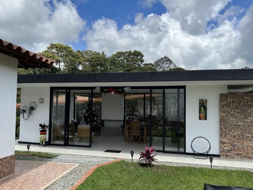 a house with glass doors and a patio at Villa Mali Circasia Quindio in Circasia