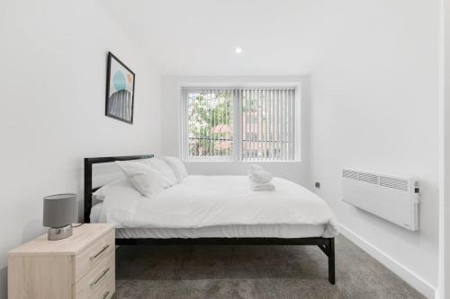 um quarto branco com uma cama e uma janela em Spacious 1 Bedroom Apartment in Central Newbury em Newbury
