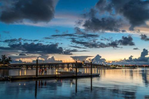 a dock in the water with a sunset at Life's a Beach in Lake Worth