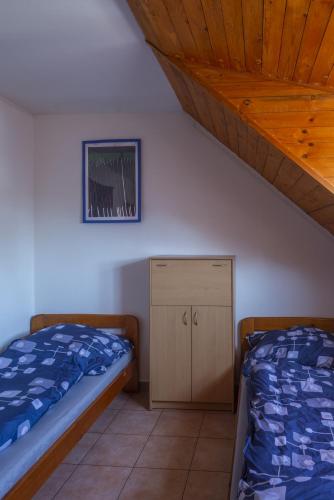a bedroom with two beds and a small cabinet at mlyn-osvracin in Osvračín