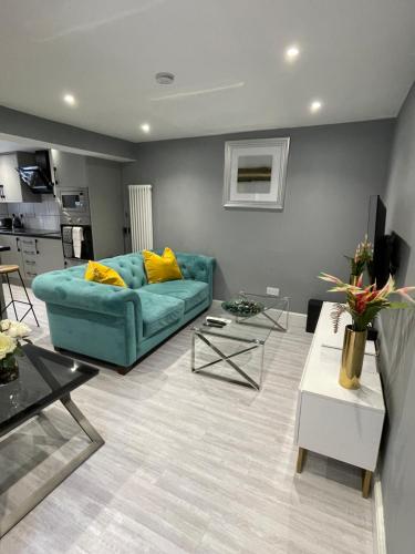 a living room with a blue couch and a table at Brook House Annex in Ipswich