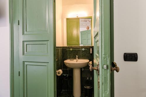 a bathroom with a sink and a mirror at Palazzo Villelmi in Cefalù