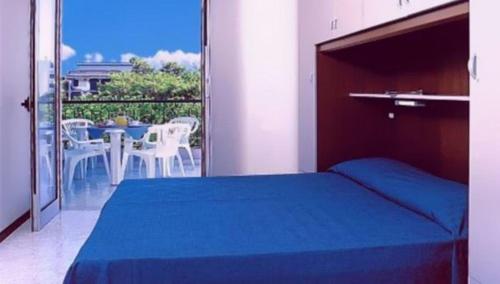 1 Schlafzimmer mit einem Bett und einem Balkon mit einem Tisch in der Unterkunft Comfortable apartment with terrace - Beahost in Bibione