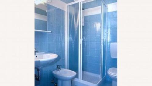 ein blaues Bad mit einer Dusche und einem Waschbecken in der Unterkunft Comfortable apartment with terrace - Beahost in Bibione