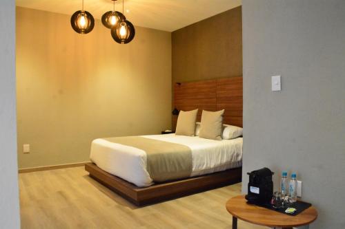 a bedroom with a bed and a table and lights at Ilo Rojo Hotel Boutique in San Miguel de Allende