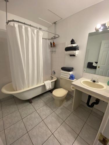 uma casa de banho com uma banheira, um WC e um lavatório. em Royal Hotel Chilliwack em Chilliwack