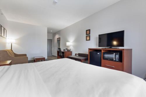 a hotel room with a bed and a flat screen tv at Comfort Suites Lombard - Addison in Lombard