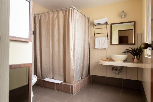 een badkamer met een douchegordijn en een wastafel bij Hostal Donde Regina in Guatemala