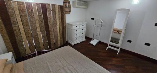 a bedroom with a bed and a dresser and a mirror at APPARTAMENTO CHIATAMONE 26 in Naples