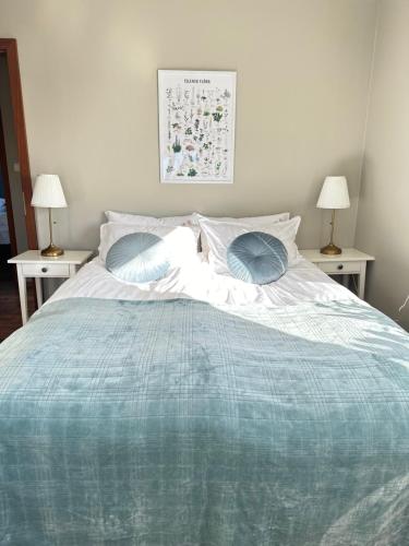 a bedroom with a bed with a blue comforter at Selið Farm Stay - Guesthouse in Álftanes