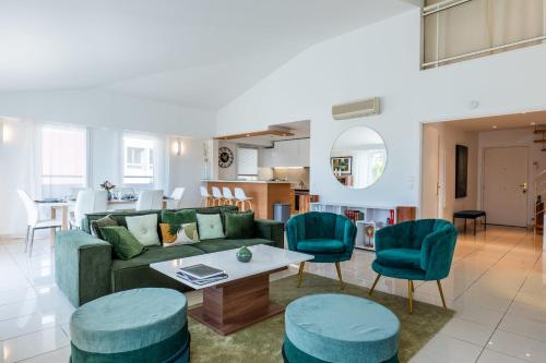 sala de estar con sofá verde y sillas azules en RARE! 120m ROOFTOP apartment 5-minute walk to downtown, en Cannes