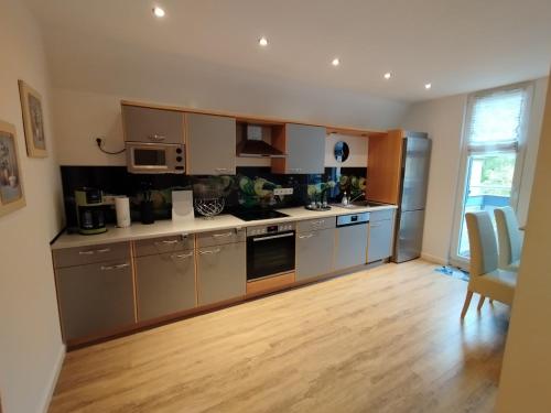 a kitchen with stainless steel appliances and wooden floors at Ferienwohnung Lehmann - Wernigerode in Wernigerode