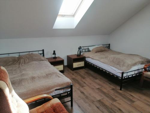 um quarto com 2 camas e uma clarabóia em Willa Malbork em Breslávia