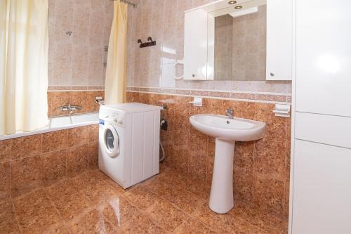 ein Badezimmer mit einer Waschmaschine und einem Waschbecken in der Unterkunft Vintage Blloku Apartment in Tirana