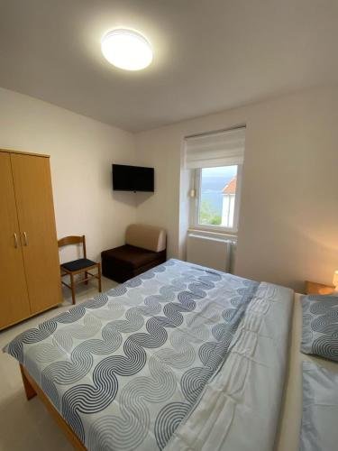 a bedroom with a large bed and a window at Apartmani Radosav in Šilo
