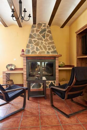 a living room with two chairs and a fireplace at CASA RURAL EL PINICO in Yeste