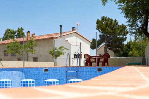 a tennis court with two red chairs in front of a building at CASA RURAL EL PINICO in Yeste
