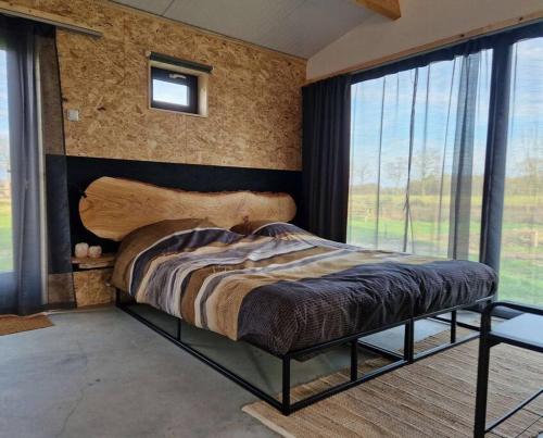 een slaapkamer met een bed met een houten hoofdeinde bij De Wilde Tuin in Moergestel