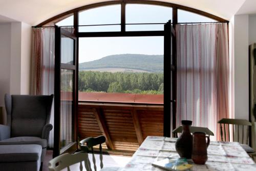 a living room with a table and a large window at Bakonyszentkirályi Menedék in Bakonyszentkirály
