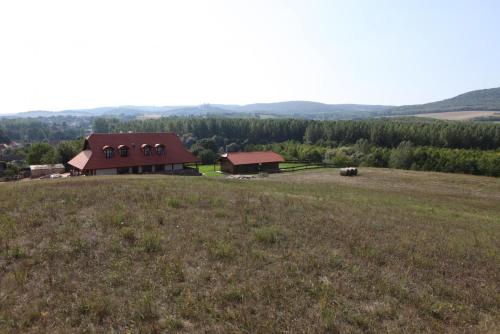 a large field with a barn on top of a hill at Bakonyszentkirályi Menedék in Bakonyszentkirály
