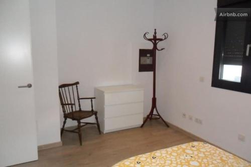 1 dormitorio con cama, silla y vestidor en Quite and brightly single room. en Sa Pobla