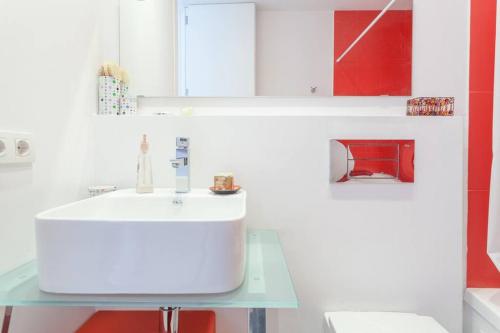 baño con lavabo blanco y armarios rojos en Quite and brightly single room. en Sa Pobla