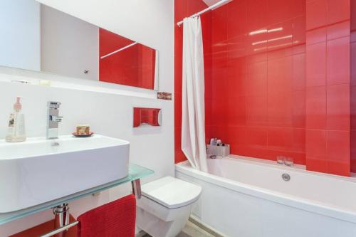 y baño rojo con aseo, bañera y lavamanos. en Quite and brightly single room. en Sa Pobla