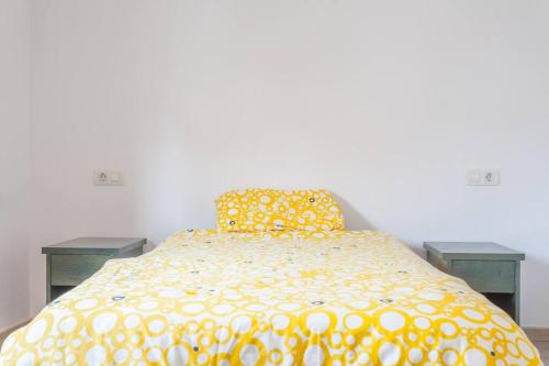 1 dormitorio con 1 cama amarilla y 2 mesas en Quite and brightly single room. en Sa Pobla