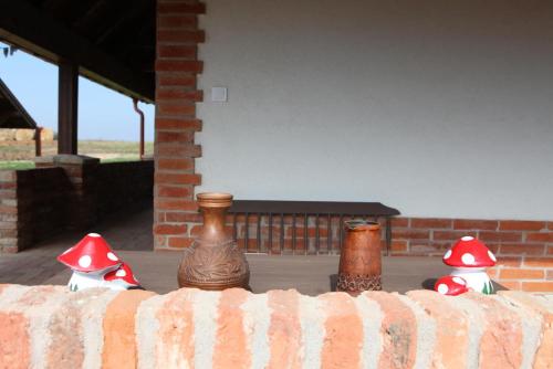 three vases with red hats sitting on a fence at Bakonyszentkirályi Menedék in Bakonyszentkirály