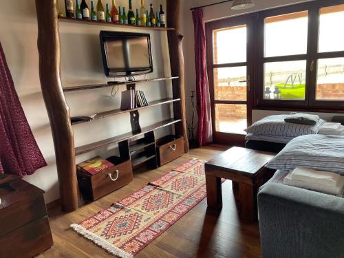 a living room with a tv and a couch and a table at Bakonyszentkirályi Menedék in Bakonyszentkirály
