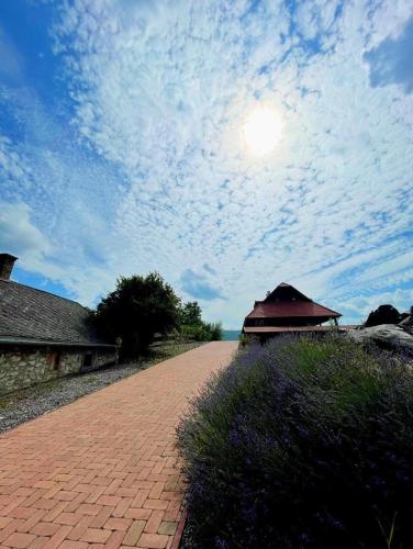 a brick road with a building and a cloudy sky at Bakonyszentkirályi Menedék in Bakonyszentkirály