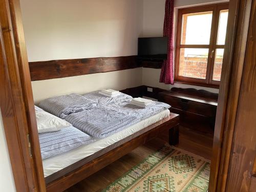 a small bed in a room with a window at Bakonyszentkirályi Menedék in Bakonyszentkirály