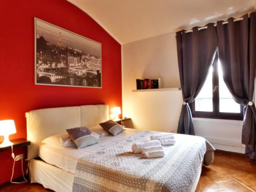 una camera da letto con un letto con pareti rosse e una finestra di Garden Sweet House Desenzano a Desenzano del Garda