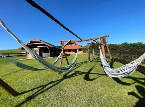 two hammocks in a yard with a house at Bakonyszentkirályi Menedék in Bakonyszentkirály