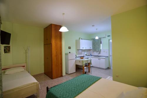 a small room with two beds and a kitchen at Elena Apartments stoypa in Stoupa