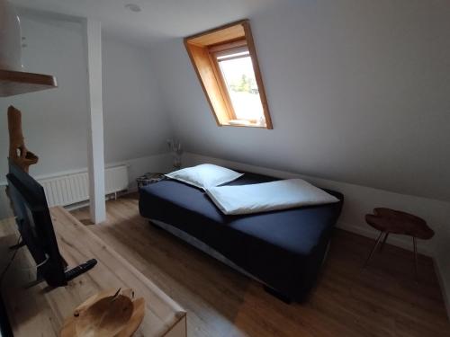 ein kleines Schlafzimmer mit einem Bett und einem Fenster in der Unterkunft Ferienwohnung Lehmann - Wernigerode in Wernigerode