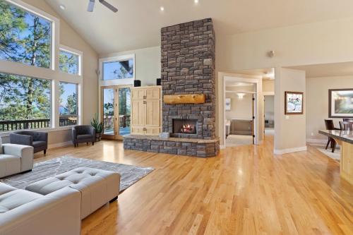 an open living room with a stone fireplace at Lucy Lou 30 Day Minimum home in Bend