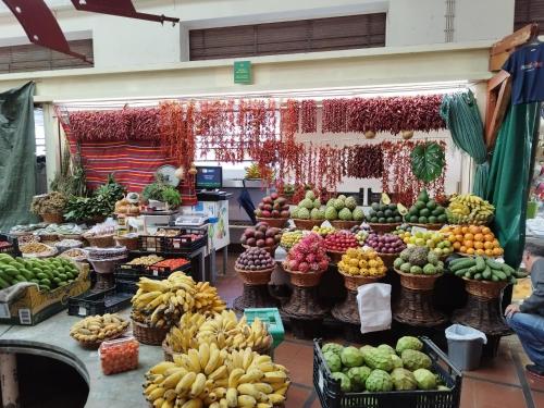 a market filled with lots of different fruits and vegetables at Alexia Room in Funchal