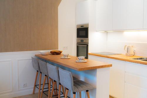 une cuisine avec un comptoir et des tabourets. dans l'établissement Velvet - By BEST KEYS - Maison Duplex Élégante - Plein Centre Ville - Déco Minimaliste & Cosy - Literie Haut de Gamme - 2 chambres séparées - Lit Queen Size & 1 canapé convertible - Smart TV - Machine à Café Nespresso - WiFi Fibre - Check-in Autonome, à Sens