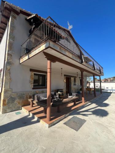 a building with a balcony and a deck at Casa Rural El Pinaron in Navaluenga