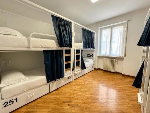 a room with three bunk beds and a wooden floor at Bovisa Urban Garden in Milan