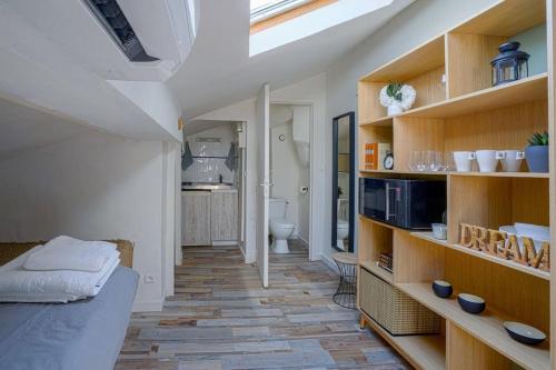 une chambre avec un lit et une chambre avec une salle de bains. dans l'établissement Studio sous les toits très bien placé et climatisé, à Montpellier