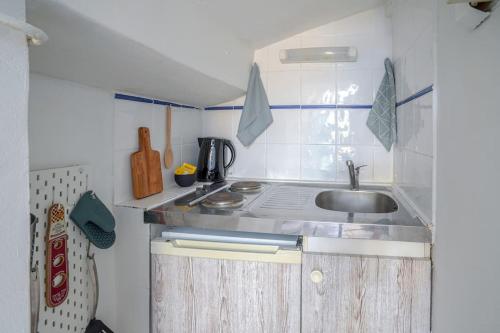 une petite cuisine avec un évier et une cuisinière dans l'établissement Studio sous les toits très bien placé et climatisé, à Montpellier