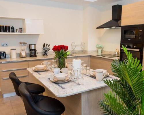 a kitchen with a counter with a table with dishes at BETH Accommodations Westlands Nairobi in Nairobi