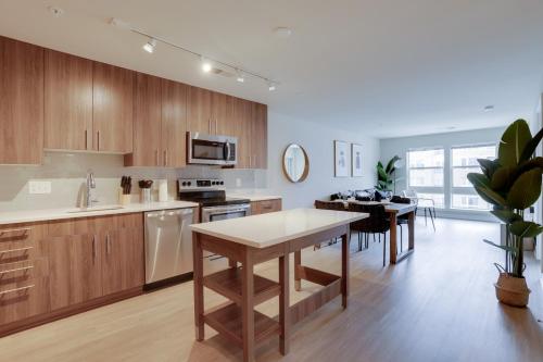 a kitchen with wooden cabinets and a dining room at Fun & Comfort Await: Apartment at Alexandria in Alexandria