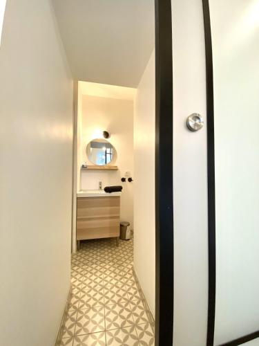 un couloir menant à une salle de bain avec un lavabo dans l'établissement Apt centre historique Vannes COUR et GARAGE privés, à Vannes