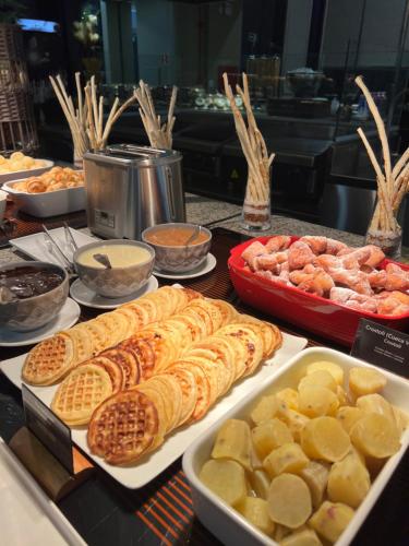 a buffet of different types of food on a table at Wyndham Golden Foz Suítes in Foz do Iguaçu