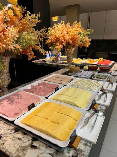 a table with many plates of food on it at Wyndham Golden Foz Suítes in Foz do Iguaçu