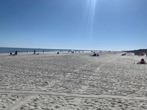 a group of people on a sandy beach at Beachy Keen Seaside Villa Near Coligny with Bikes! in Hilton Head Island